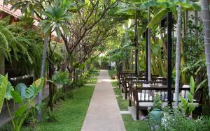 a row of benches in a garden with trees at The Urban in Siem Reap