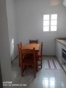 a table and chairs in a kitchen with a window at DVLNG FAMILY STUDIO APARTMENT in Kassiopi