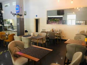 a restaurant with tables and chairs and a bar at Agentour Guesthouses in Luanda