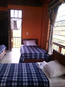 een slaapkamer met 2 bedden en een raam bij Casa De Los Colores in Paipa