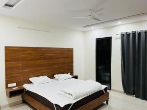 - une chambre avec un grand lit et une tête de lit en bois dans l'établissement OYO Yulive Residency Near Appu Ghar, à Gurgaon