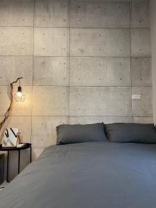 a bedroom with a bed and a concrete wall at Seagather海遇旅宿 in Green Island