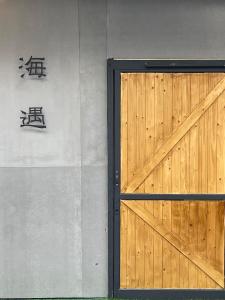 una puerta de madera con un banco en la pared en Seagather海遇旅宿 en Green Island
