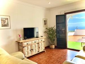a living room with a tv on a dresser at Buenos Sueños- Balcon de Frigiliana in Frigiliana