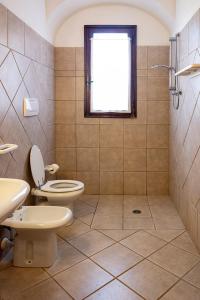 een badkamer met een toilet en een douche met een raam bij I Fiori di Salici in Capoliveri