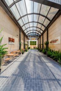 Un pasillo vacío con techo de cristal y plantas. en Sulaf Luxury Hotel, en Amán