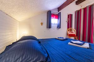 Un dormitorio con una cama azul y una ventana en Chalet en Castel, en Ax-les-Thermes