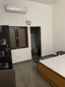 a room with a bed and a bathroom with a toilet at Shree Hari Kripa Dham in Jait