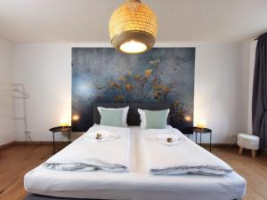 um quarto com uma grande cama branca e duas mesas em BohnApartments - Design Suiten Am Markt - Vollausstattung - WLAN - Zentrum - Vollausstattung em Ilmenau