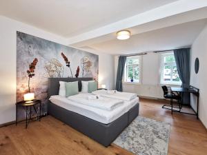 a bedroom with a large bed and a desk at BohnApartments - Design Suiten Am Markt - Vollausstattung - WLAN - Zentrum in Ilmenau