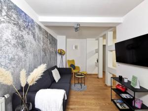 ein Wohnzimmer mit einem Sofa und einem TV in der Unterkunft BohnApartments - Design Suiten Am Markt - Vollausstattung - WLAN - Zentrum - Vollausstattung in Ilmenau