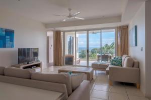 sala de estar con sofá y TV en Coral Cove Apartments en Bowen