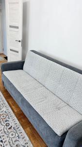 un sofá azul sentado en una sala de estar en Dostyk en Almaty
