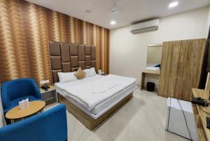 Schlafzimmer mit einem Bett, einem Tisch und Stühlen in der Unterkunft Hotel Mandakini Royale Near PVR Deep Cinema Hall Kanpur in Kānpur