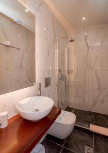 bagno con lavandino bianco e doccia di Fiori Hotel a Gouviá