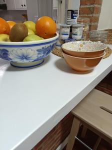 a counter with bowls of fruit and a bowl of oatmeal at Pensión liebana in San Vicente de la Barquera