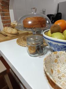 eine Theke mit einem Kuchen und einer Schale Obst in der Unterkunft Pensión liebana in San Vicente de la Barquera