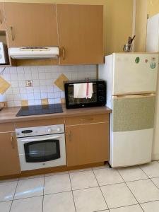 a kitchen with a microwave and a refrigerator at Le concorde T2 au cœur du Grand Carré hypercentre proche CHU in Saint-Denis