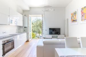 Elena House Apartments في فياريجيو: مطبخ أبيض مع أريكة بيضاء وغرفة معيشة