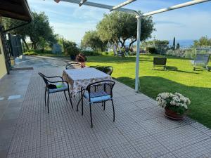 una mesa y sillas en un patio en CASA VISTA MARE - Superb garden and Parking included en Imperia