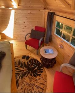 Habitación con 1 cama, 2 sillas y mesa. en Camping Paradis le Moulin des Oies, en Belz