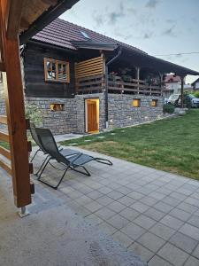 a chair sitting on a patio in front of a house at Kuća za odmor Jadra in Duga Resa