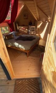 una cama en el medio de una habitación en una casa pequeña en Camping Paradis le Moulin des Oies, en Belz