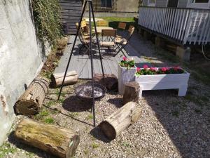 een tuin met een tafel en een stoel en wat houtblokken bij Bursztynowe Domki w Helu in Hel