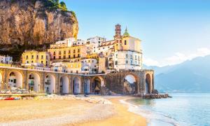een gebouw aan de kant van een berg naast het water bij Donna Lena Relais Napoli in Napels