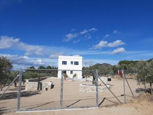 un cancello di fronte a un edificio bianco di Casita del embalse con encanto a Biar