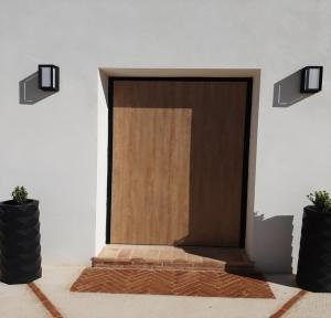 une porte en bois dans une pièce avec deux plantes en pot dans l'établissement Casita del embalse con encanto, à Biar