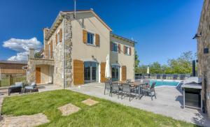 a patio with a table and chairs and a pool at Villa Stara Hiza in Novaki Pazinski