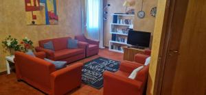 een woonkamer met rode stoelen en een tv bij Hotel Marina in Torri del Benaco