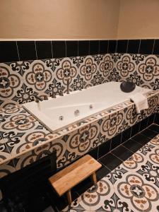 a bath tub in a bathroom with a tile floor at RARE Heritage House in George Town