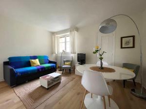 sala de estar con sofá azul y mesa en Le parc de l'Hermitage en Le Touquet-Paris-Plage