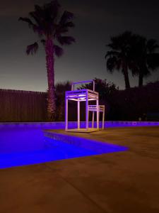 - une chaise blanche assise à côté de la piscine la nuit dans l'établissement Villa Nawel Piscine privée sans vis-à-vis, à Agadir