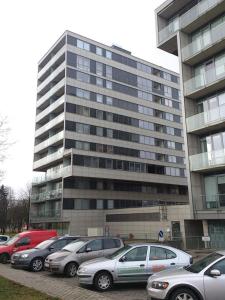 ein großes Gebäude mit davor geparkt in der Unterkunft Centro apartamentai - Vingio apartamentai in Vilnius
