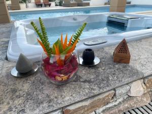 a vase filled with vegetables on a counter next to a swimming pool at Chambre d’hôtes Corse Villa Anna in Vescovato