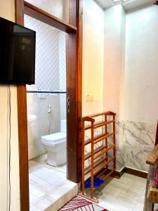 a bathroom with a toilet and a tv in it at Amazing Apartment Free Parking & Security in Dar es Salaam