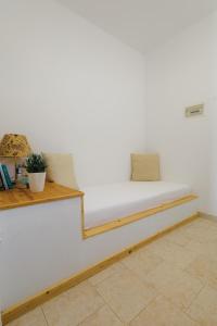 a bed in a room with a white wall at Studios Eliza in Livadi