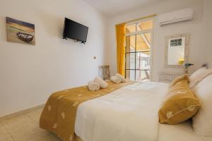 a bedroom with a large white bed with towels on it at Studios Eliza in Livadi