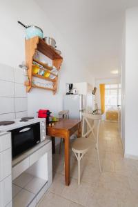 a small kitchen with a wooden table and a stove at Studios Eliza in Livadi