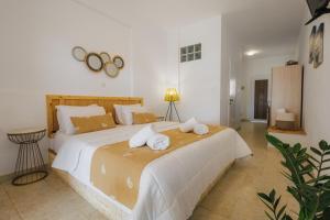 a bedroom with a large bed with towels on it at Studios Eliza in Livadi