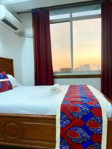 a bedroom with a bed and a large window at Amazing Apartment Free Parking & Security in Dar es Salaam