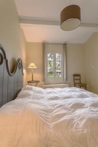 1 cama blanca grande en una habitación con ventana en Maison au cœur des corbières, en Saint-Laurent-de-la-Cabrerisse