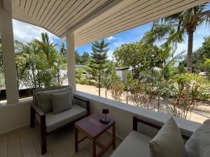 una sala de estar con vistas a la playa y a las palmeras. en Moorea Boutique Resort Samui, en Koh Samui 
