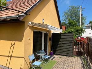 2 chaises et une table à l'extérieur d'une maison dans l'établissement Viola Kisház, à Siófok