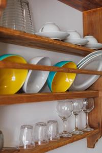 a bunch of dishes and glasses on shelves at Studios Eliza in Livadi