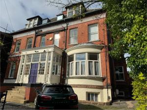 une voiture garée devant une maison en briques dans l'établissement Airy Apartment Sefton Park, à Liverpool