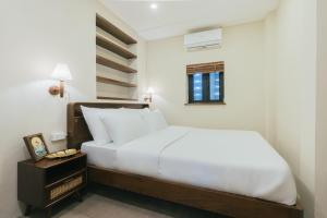 a bedroom with a white bed and a night stand at Lily Hidden Homestay in Hanoi